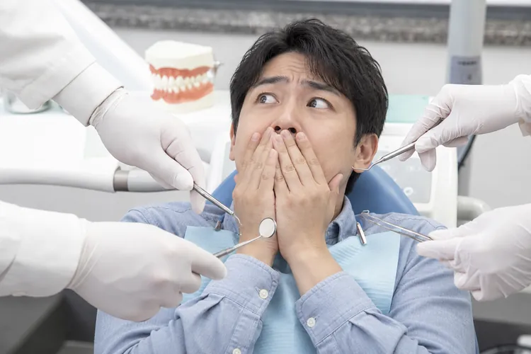 被手持诊疗器械的手包围、惊恐捂嘴的男性