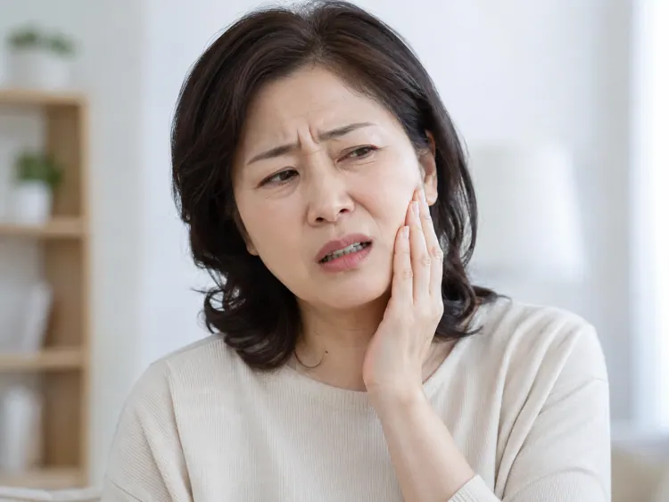 捂着脸颊、面露痛苦的女性